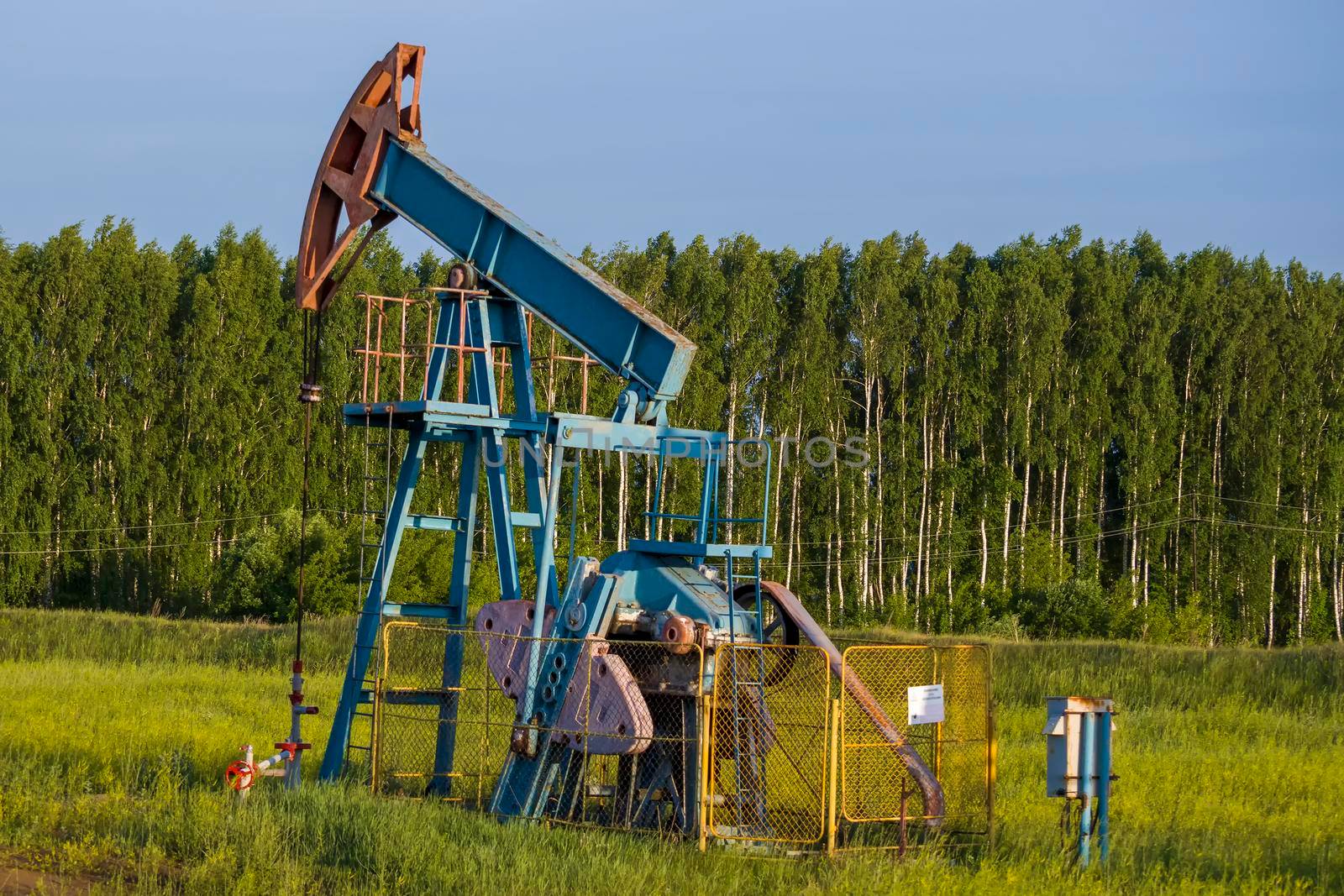 Working oil pump from oil field. Industrial equipment. Bashkortostan, Russia - 12 June, 2021. by Essffes