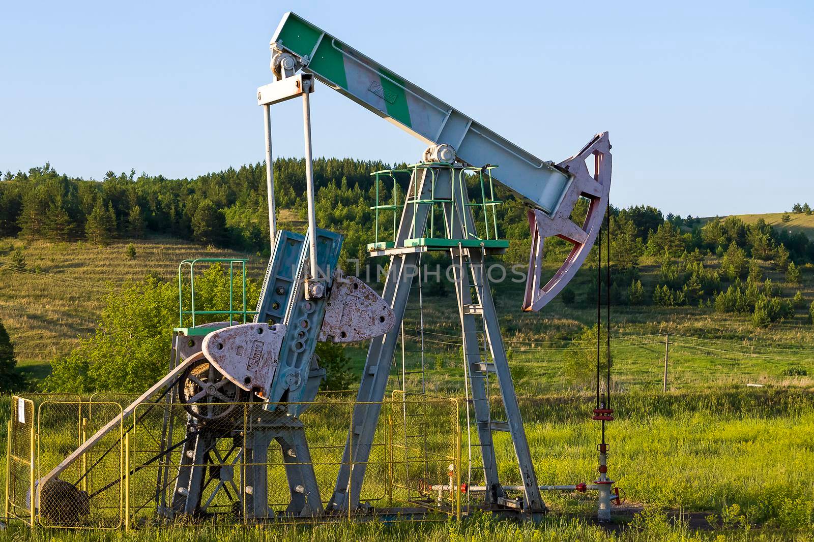 Working oil pump from oil field. Industrial equipment. Bashkortostan, Russia - 12 June, 2021. by Essffes