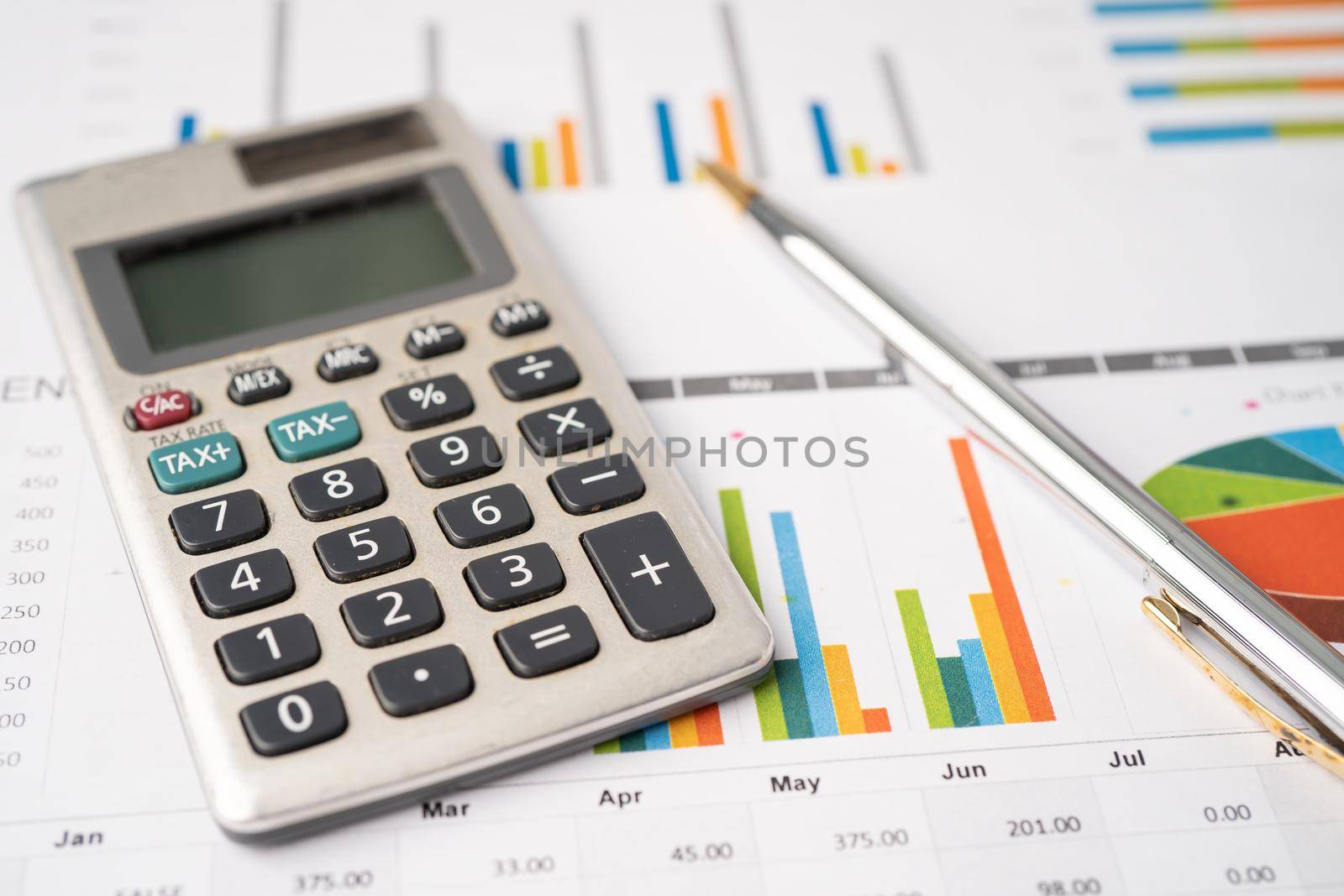 Calculator with pen on chart graph paper, finance, account, statistic, analytic economy Business concept. by pamai