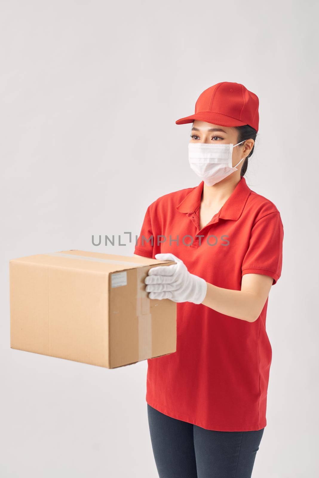 Delivery woman holding cardboard boxes in medical rubber gloves and mask on white background. 