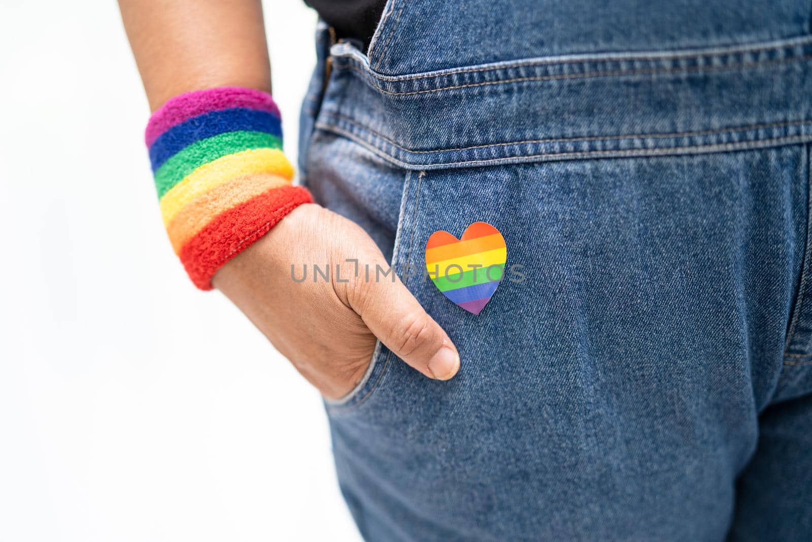 Asian lady wearing rainbow flag wristbands, symbol of LGBT pride month celebrate annual in June social of gay, lesbian, bisexual, transgender, human rights.