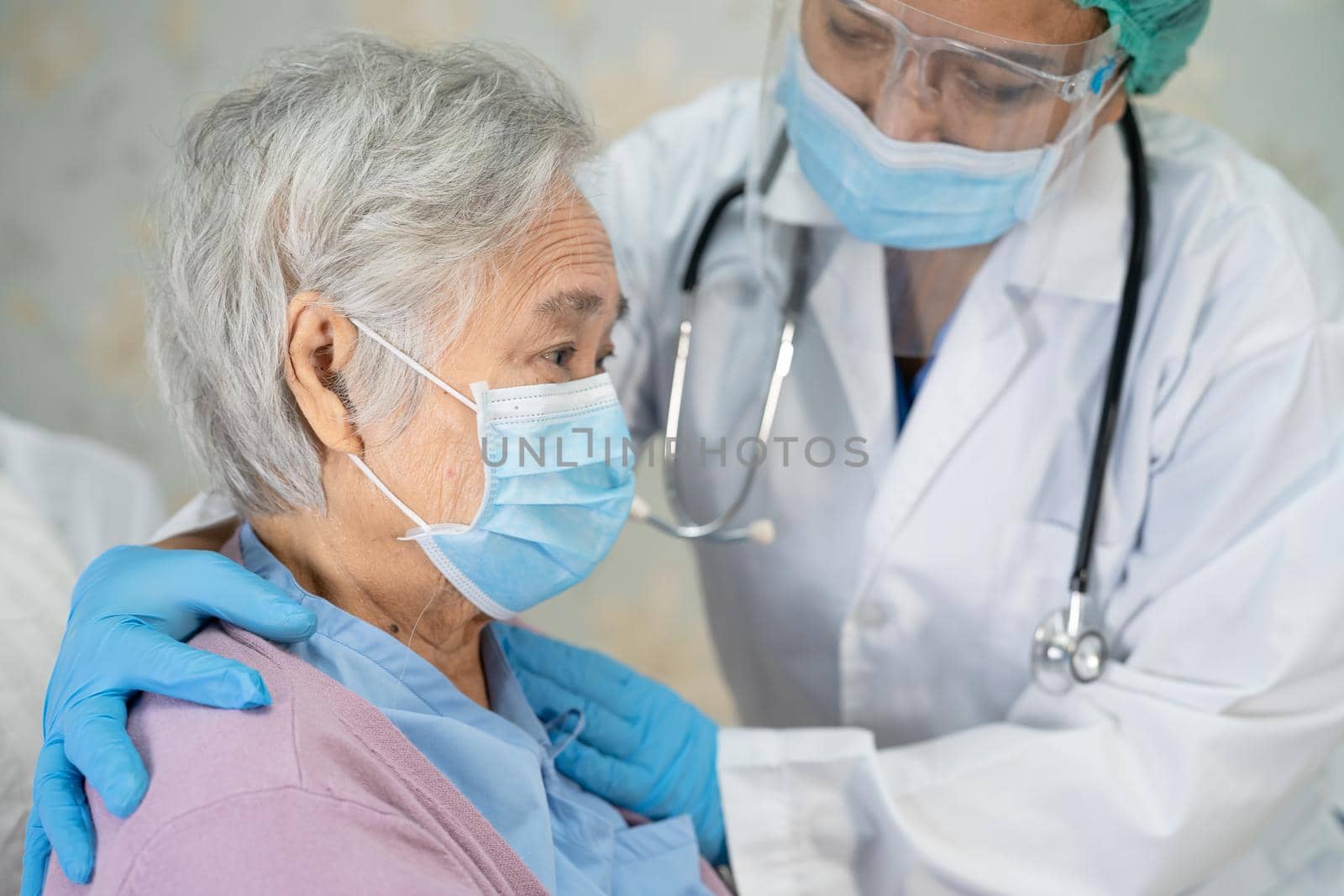 Doctor checking Asian senior or elderly old lady woman patient wearing a face mask in hospital for protect infection Covid-19 Coronavirus. by pamai