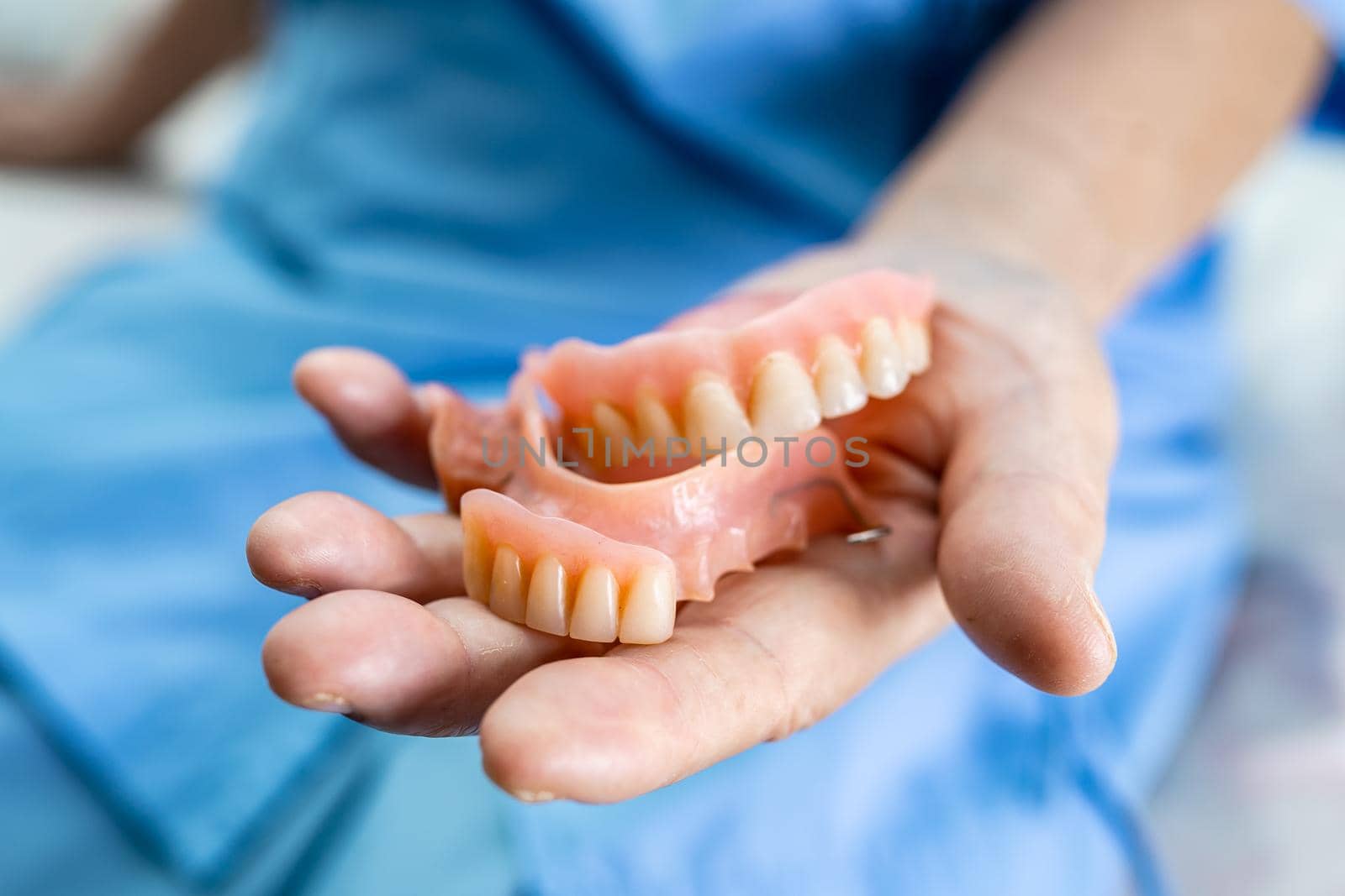 Asian senior or elderly old woman patient holding to use denture in nursing hospital ward, healthy strong medical concept by pamai