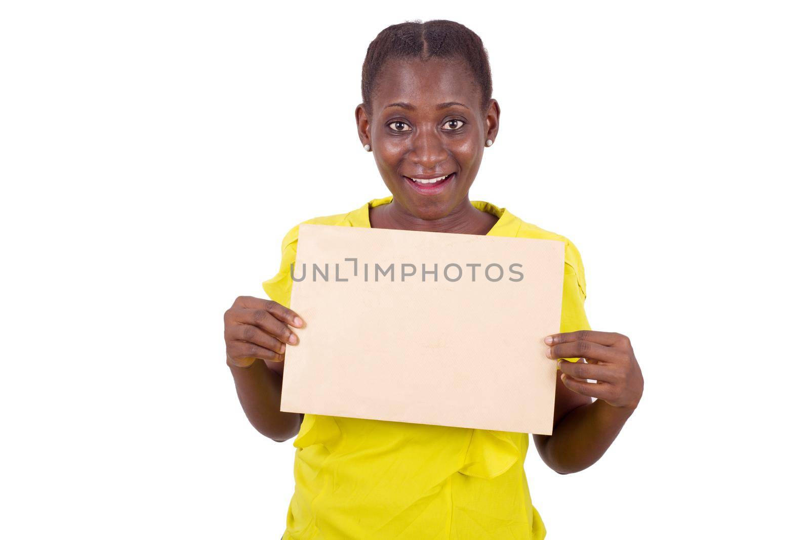 young girl standing in yellow camisole with envelope glued to the chest looks at the camera smiling.