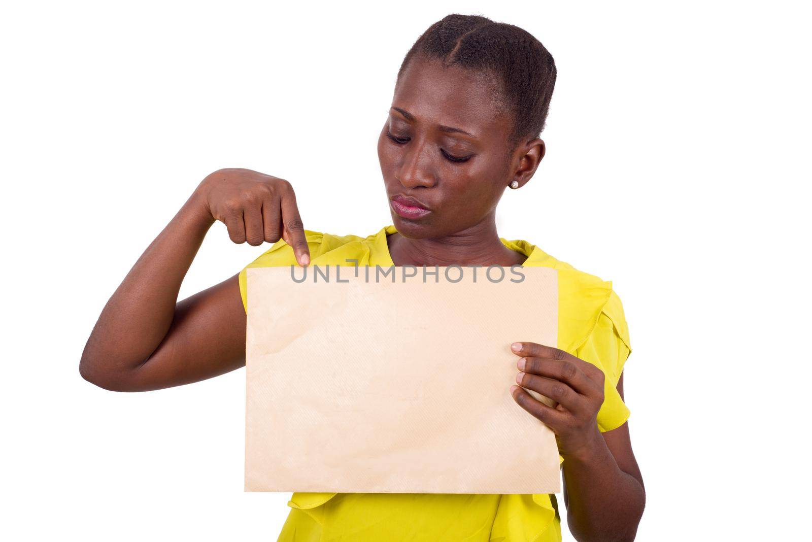 young girl standing in yellow camisole pointing at an envelope stuck to her chest.