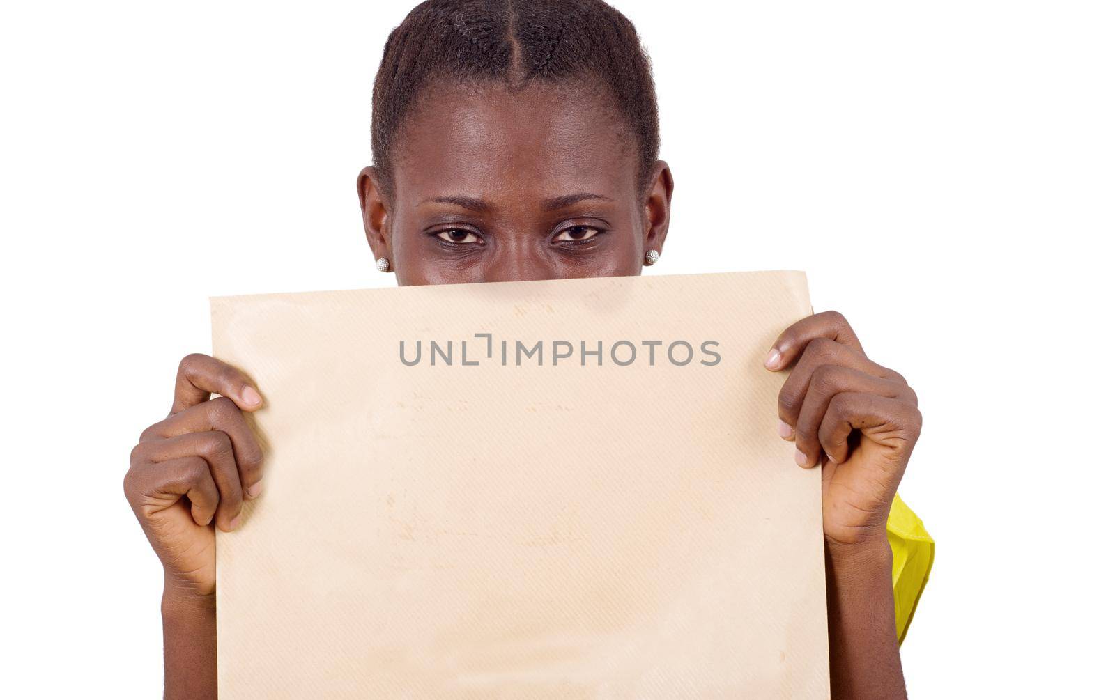 young girl standing in yellow camisole with khaki envelope closing mid face and looking at the camera.