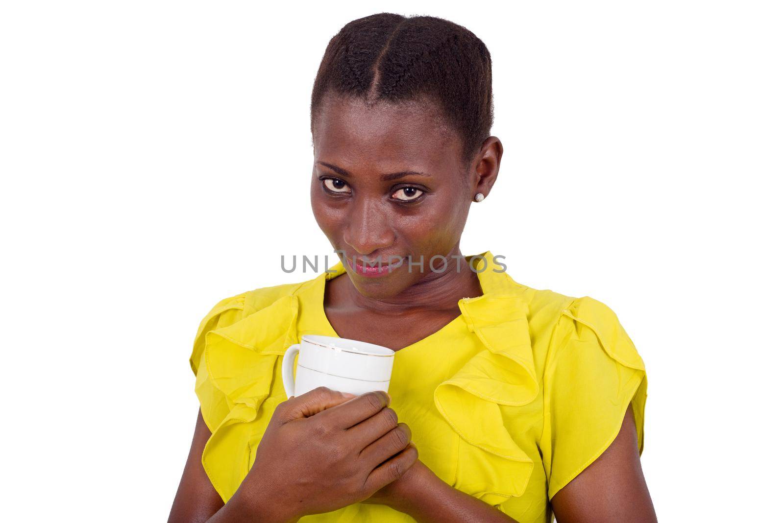 young girl standing in yellow camisole cup against chest looking at camera smiling
