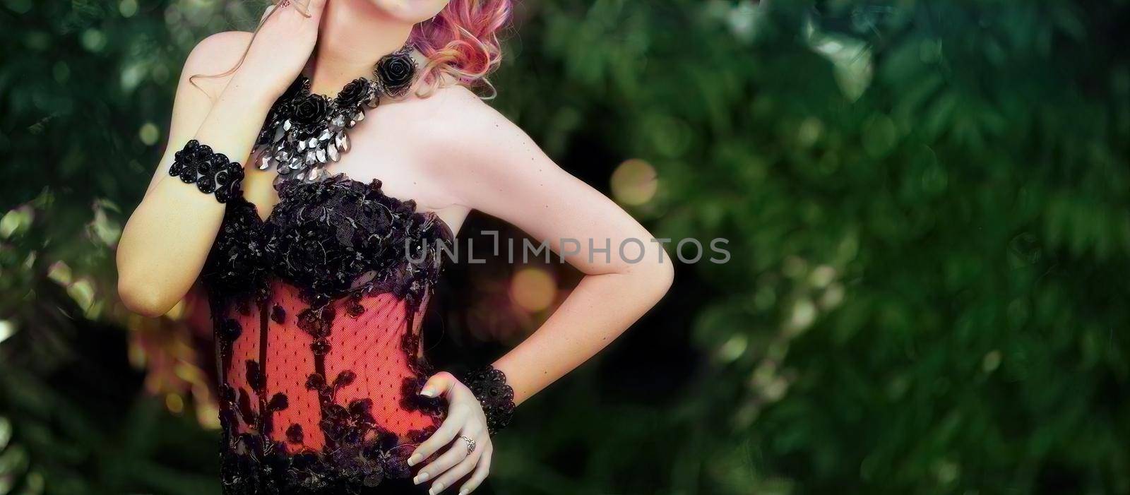 Soft focus - Elegant young woman posing outdoors in an embroidered black dress. Colorized image.