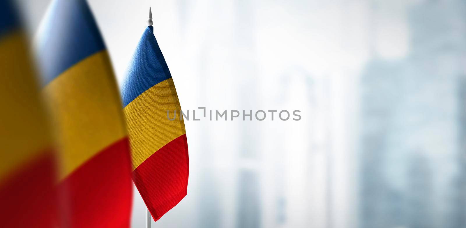 Small flags of France on a blurry background of the city.