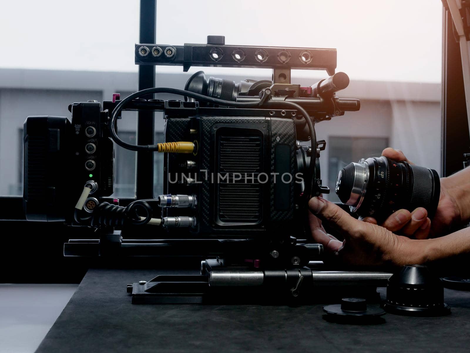 Close Up human hand inserting the cinema lens into a movie camera mount. by wattanaphob