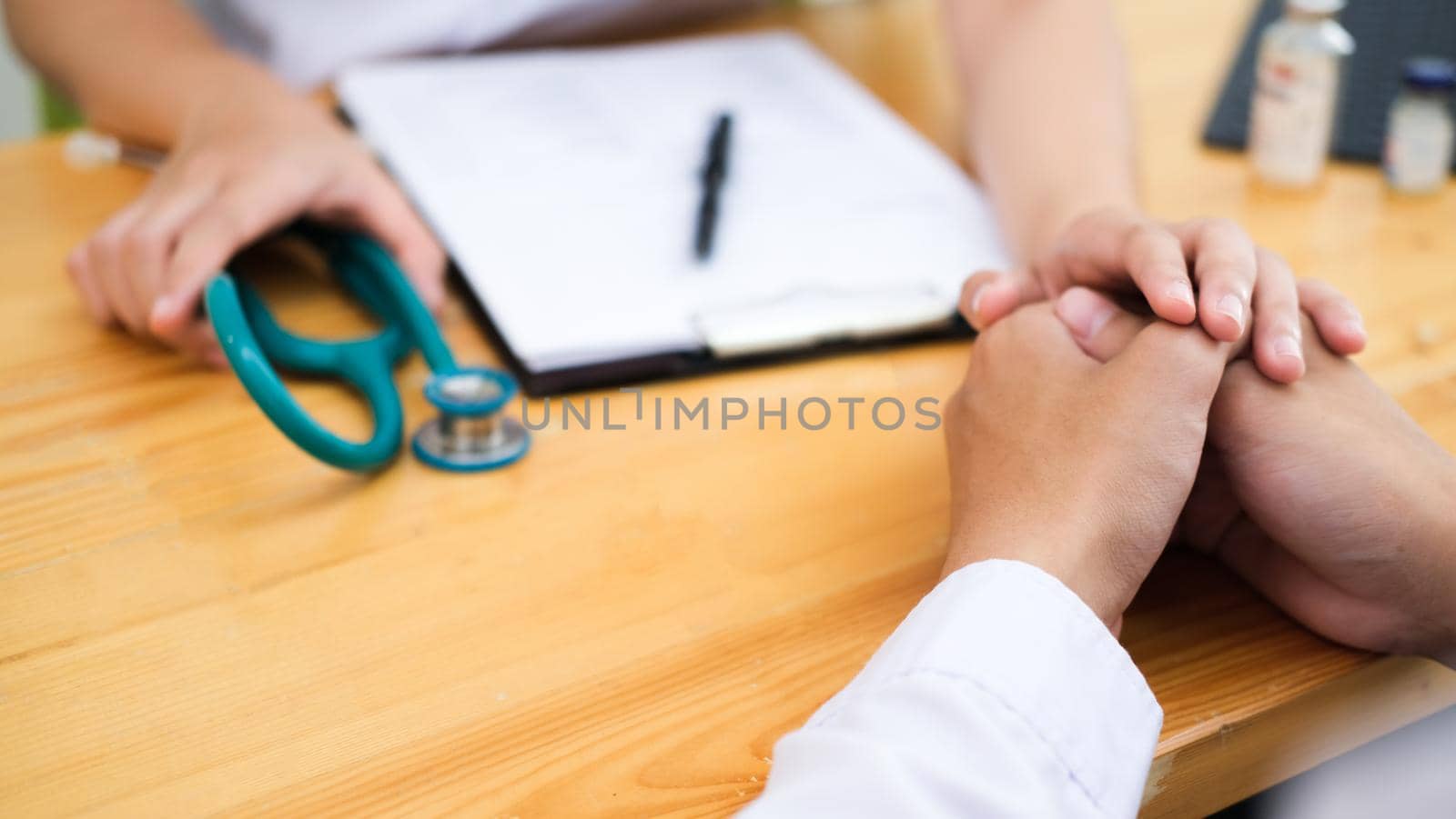 Doctor comforting patient at consulting room