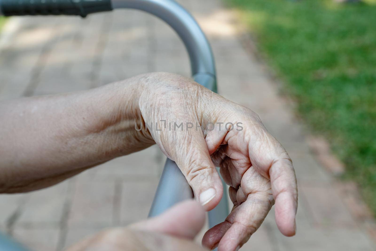 Elderly woman using a walker in backyard