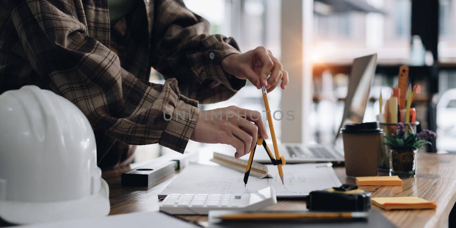 Architect or Engineer working with compasses and blueprints for architectural plan,engineer sketching a construction project concept by itchaznong