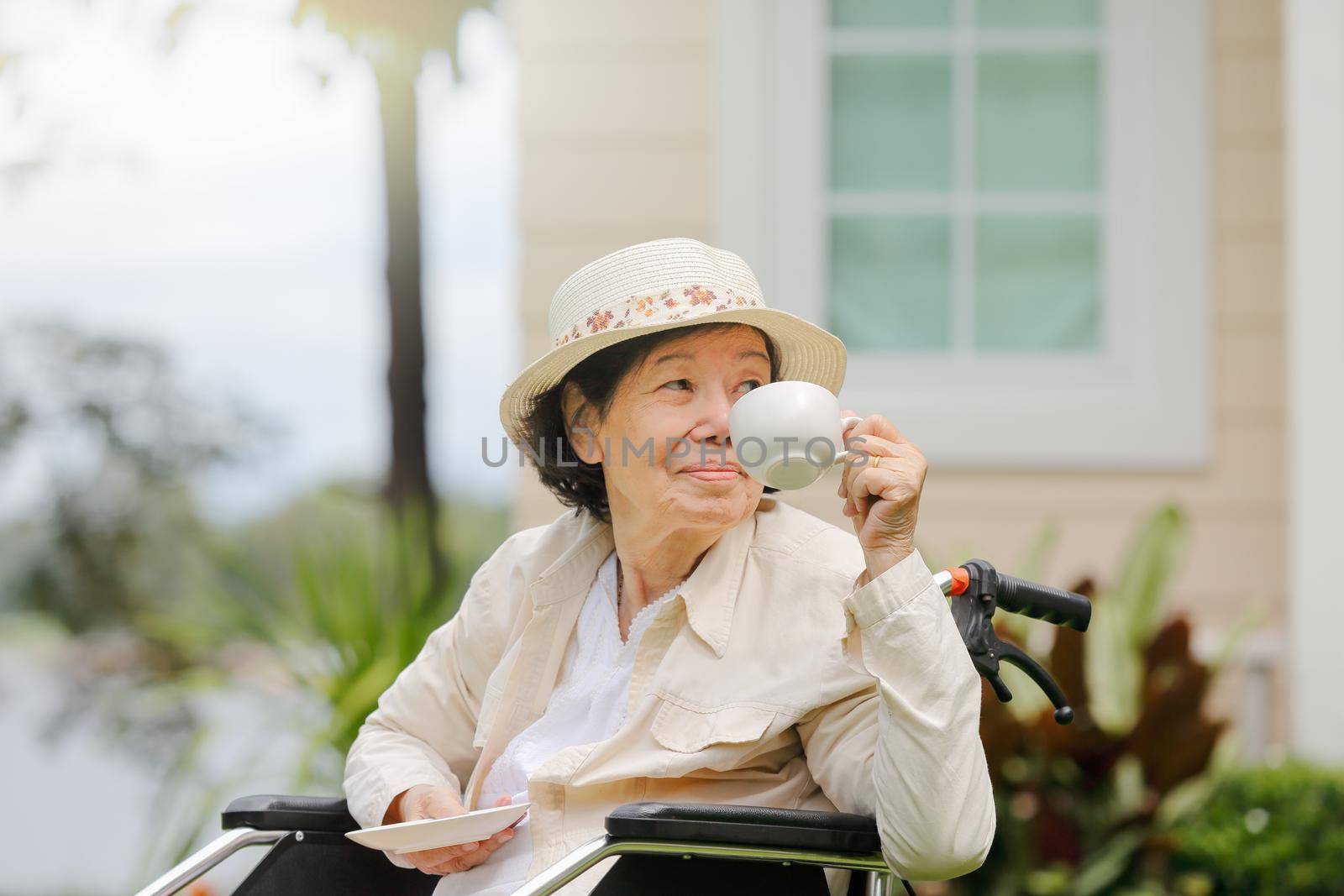 Elderly woman relax on wheelchair in backyard