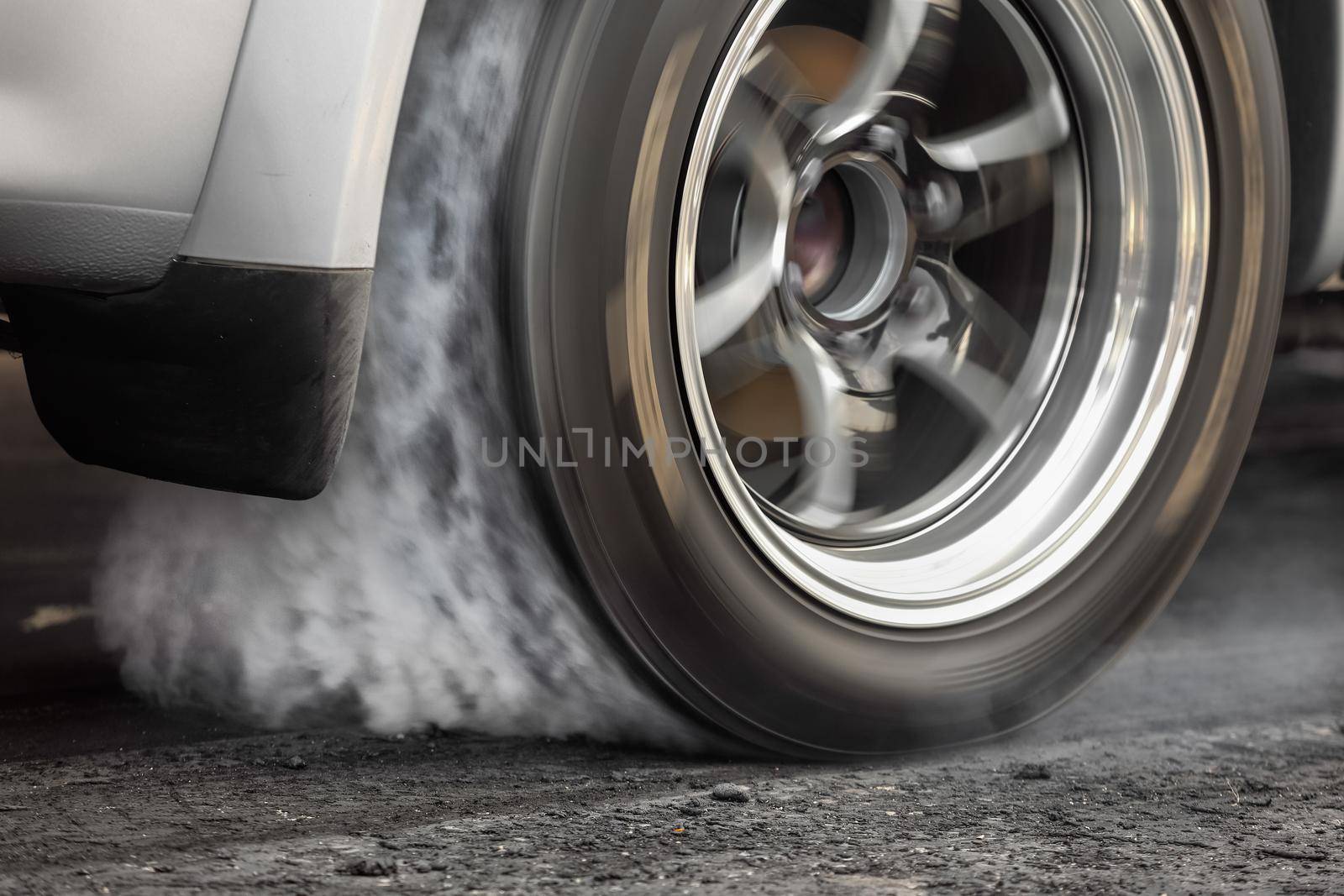 Drag racing car burns rubber off its tires in preparation for the race