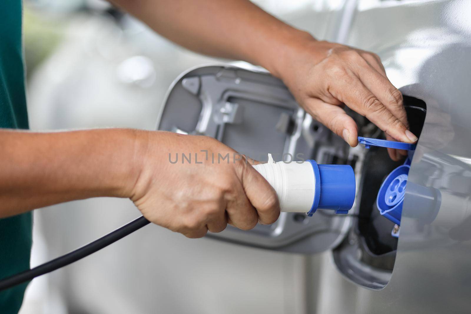 Charging an electric car with the power cable supply plugged in