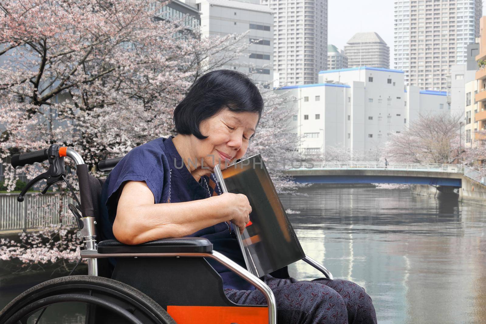 Senior asian woman sleepy while reading magazine in park by toa55