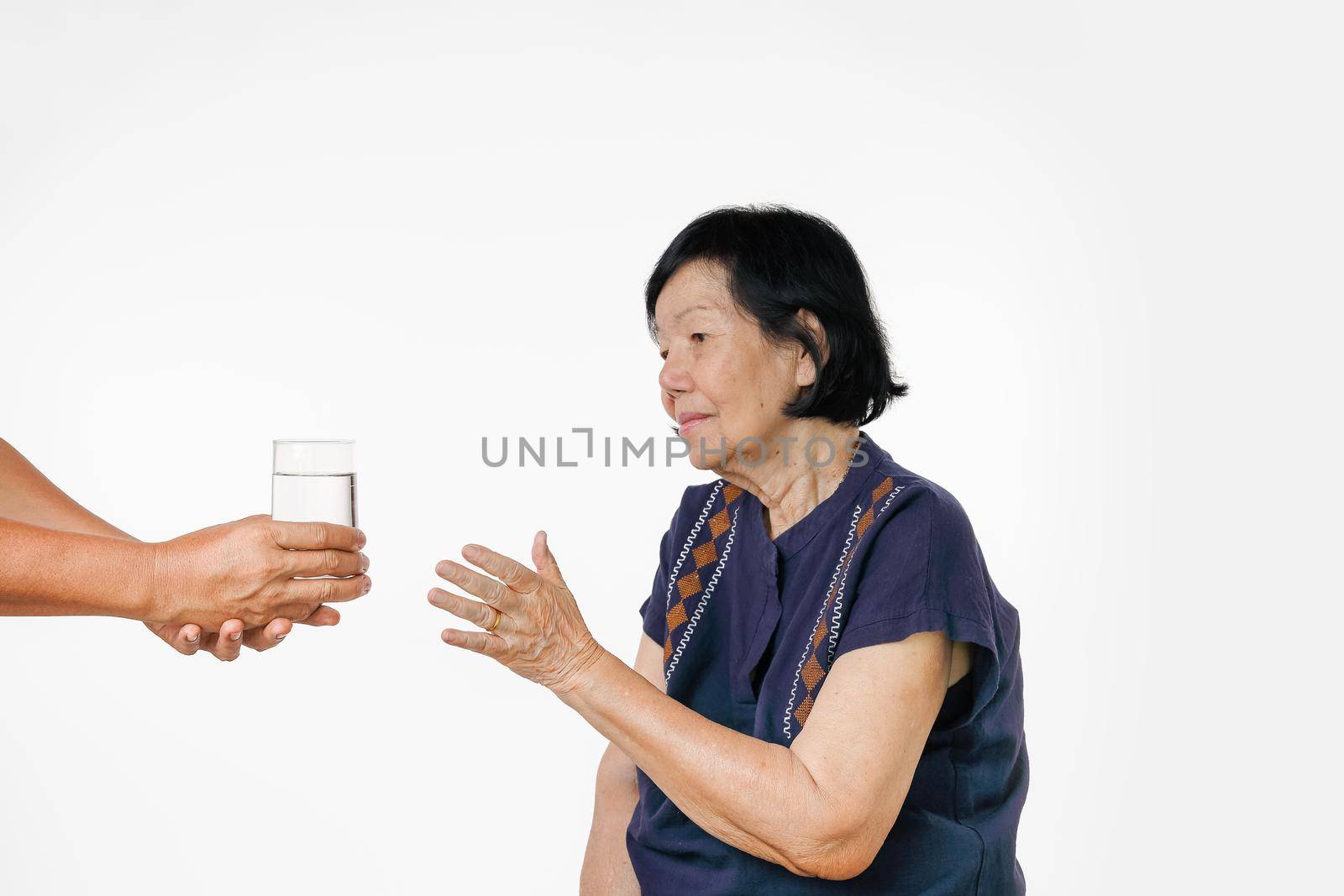 elderly woman gets a glass of water and her pills from caregiver by toa55