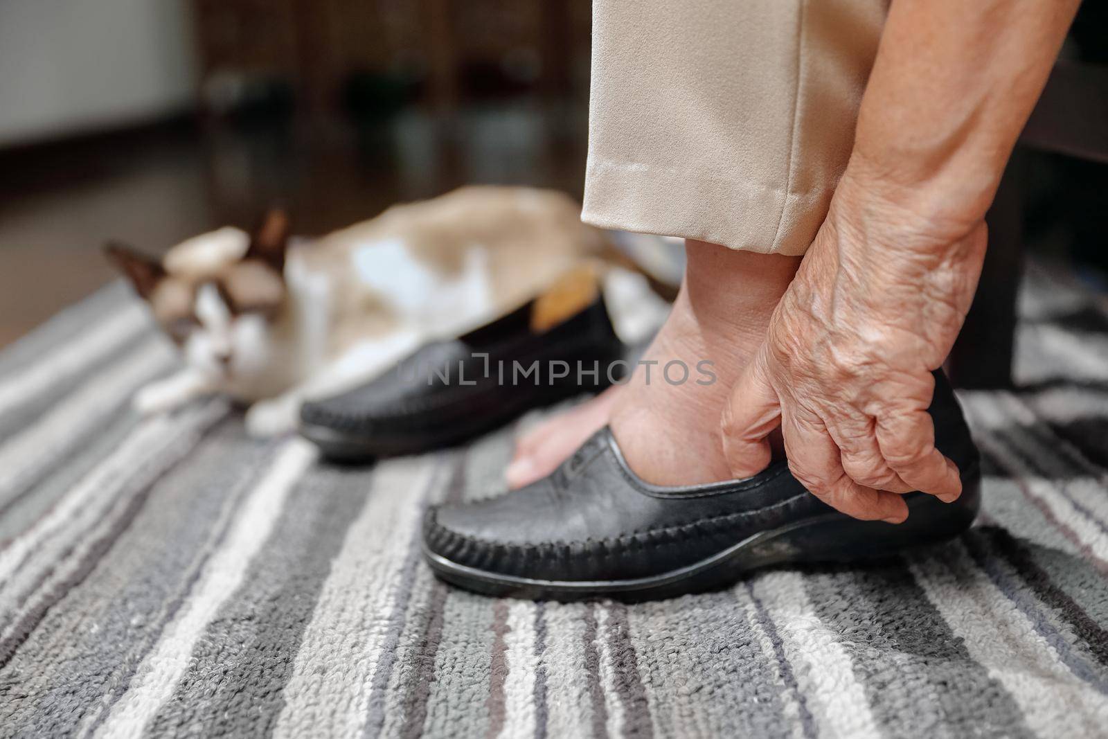 Elderly woman swollen feet putting on shoes by toa55