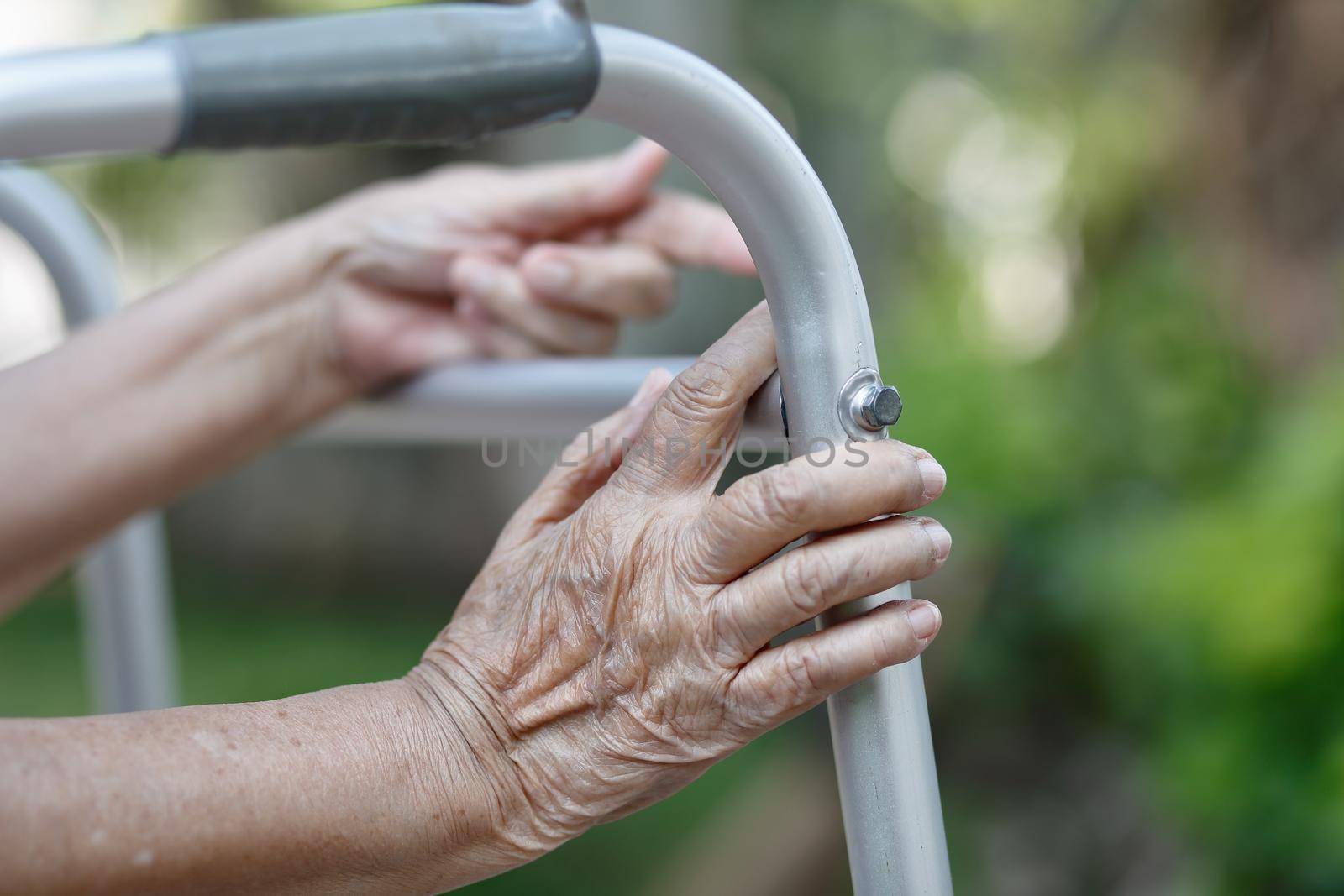 Elderly woman using a walker in backyard