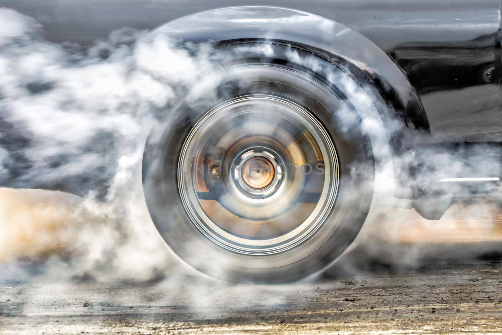 Drag racing car burns rubber off its tires in preparation for the race