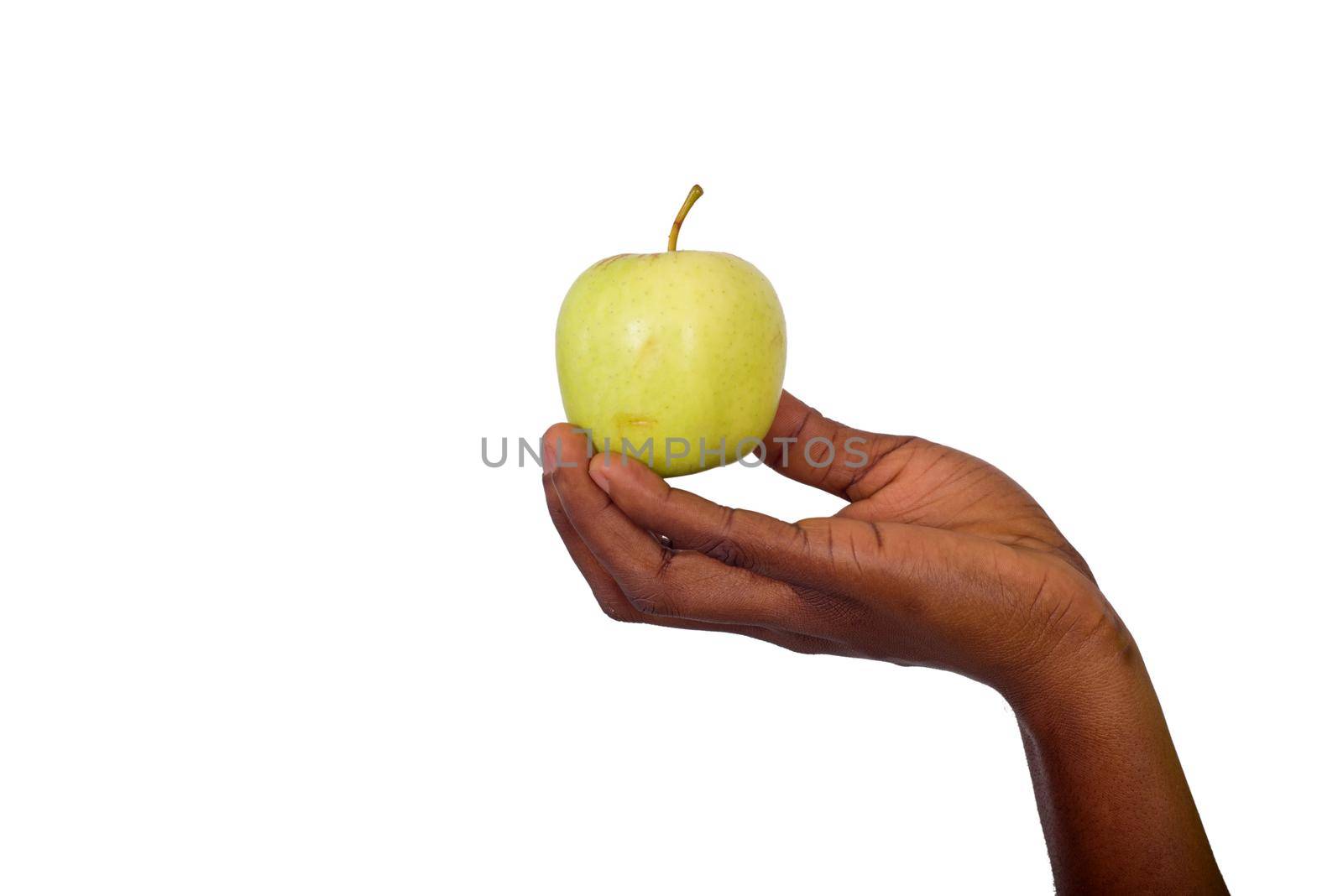 female hand holding apple on gray background.