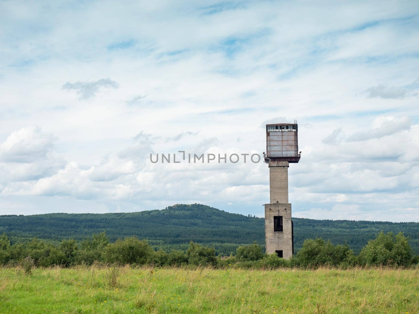 Mine tower and abandoned residues from iron and copper ore mining under Medenec hill. Popular tourist region in Ore mountains, north Czechia.
