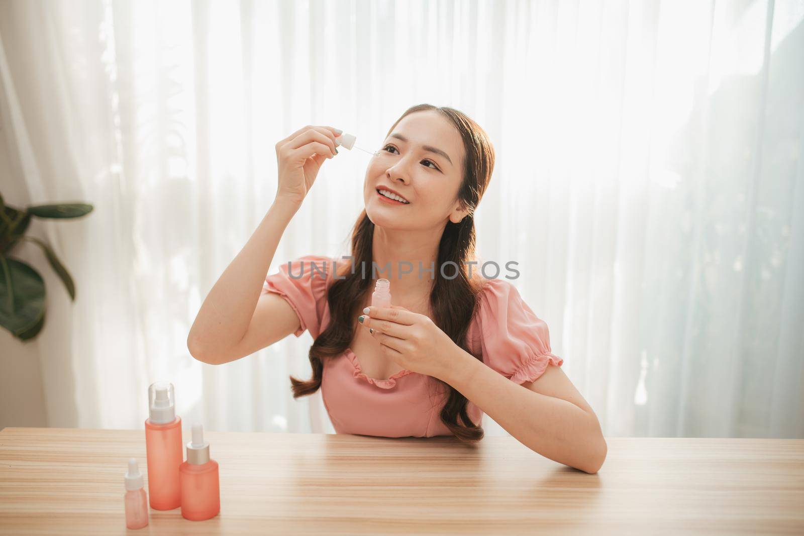 Beauty blogging. Makeup and face care tutorial. Young attractive woman holds in her hands a beauty product