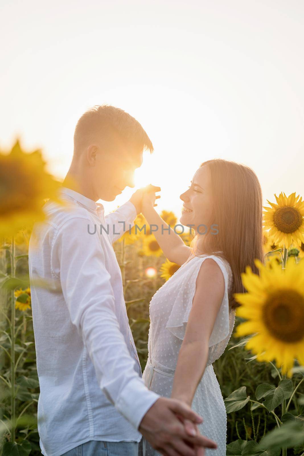 Beautiful couple having fun and dancing in sunflowers fields by Desperada