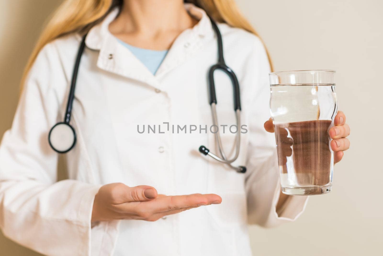 Image of female doctor showing on glass of water.