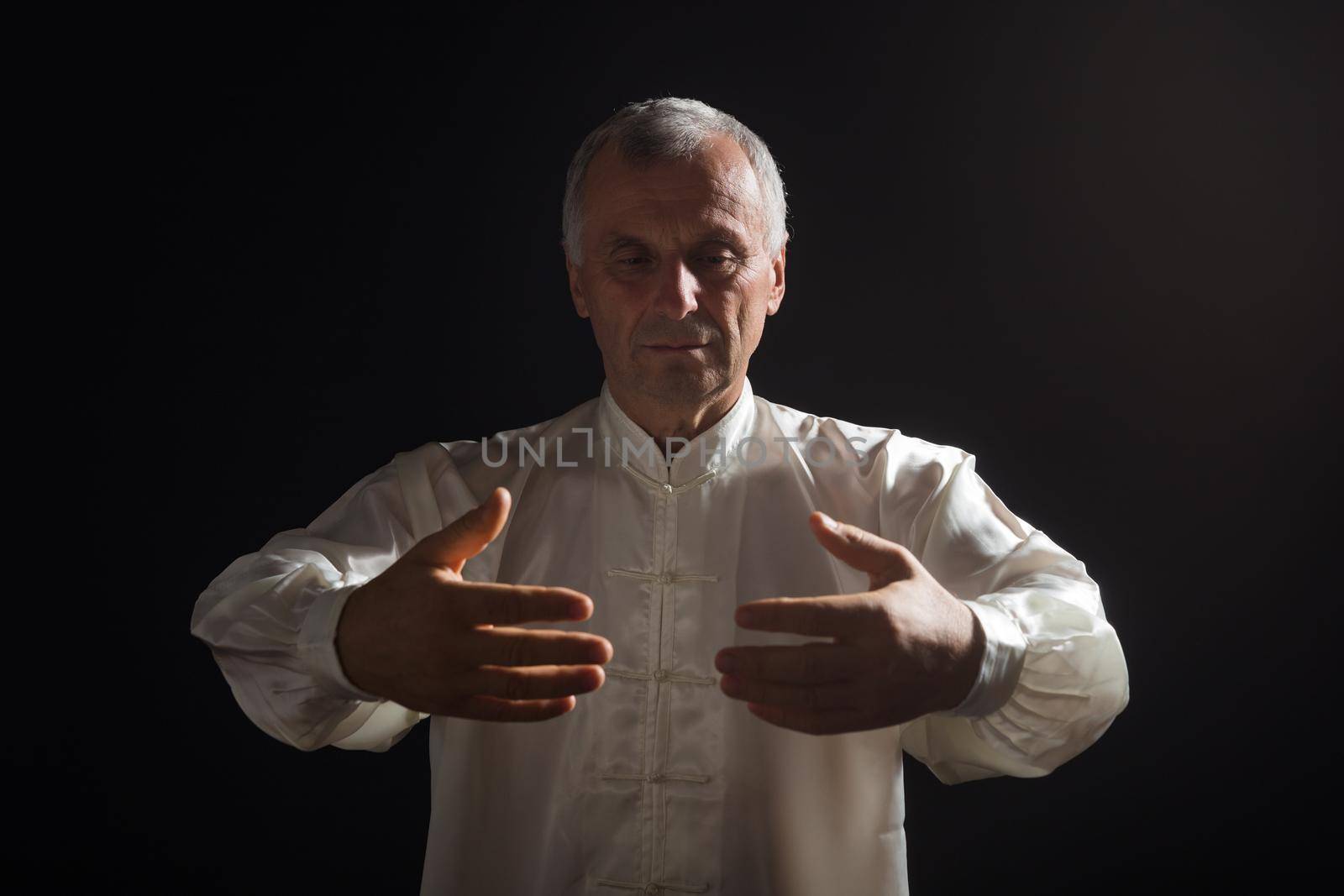 Senior man enjoys exercise Tai Chi indoor.