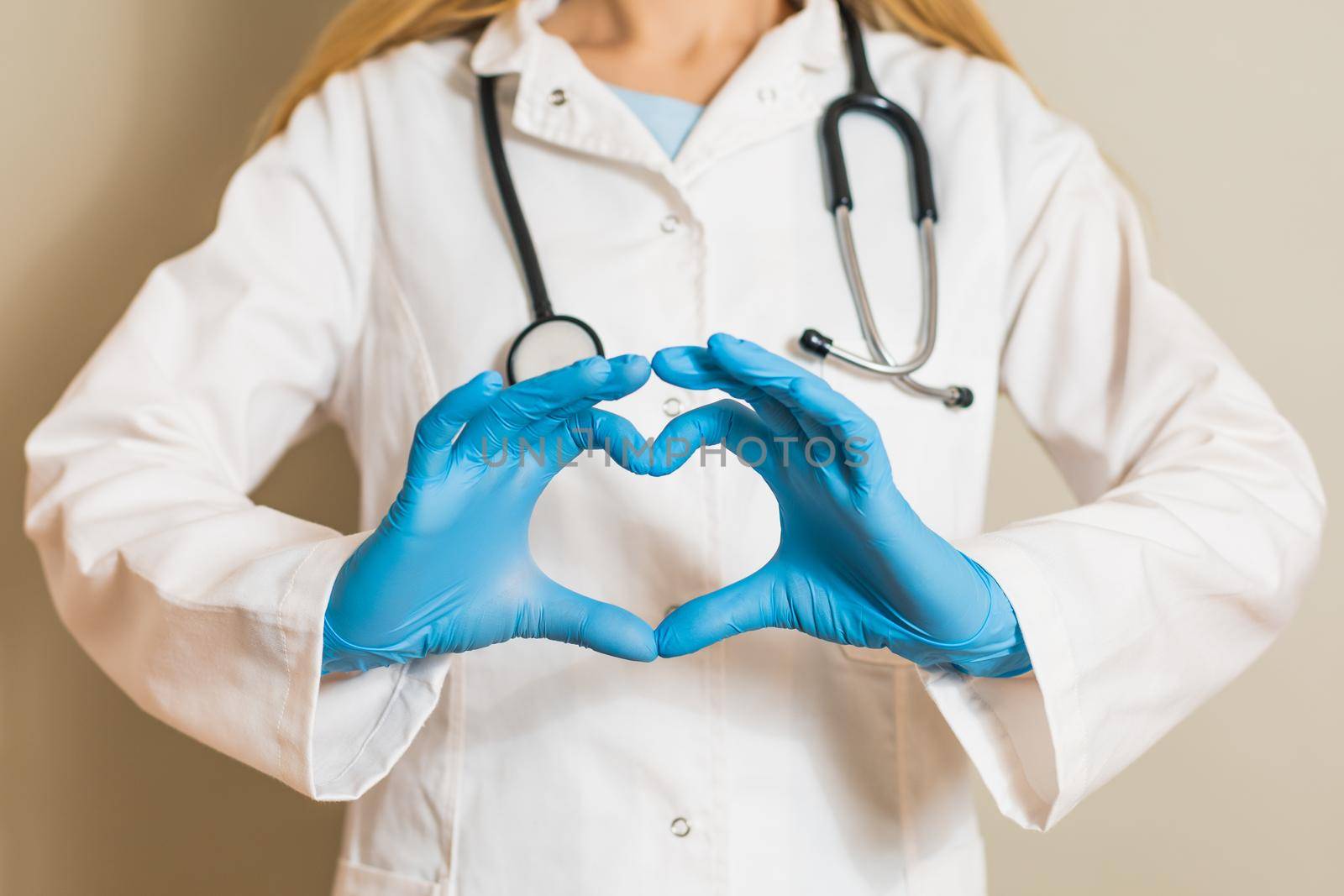 Image of female doctor showing heart shape with hands.