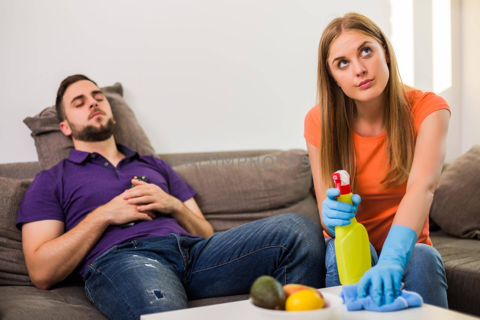 Angry wife and husband are having conflict because husband is never helping his wife with cleaning house.