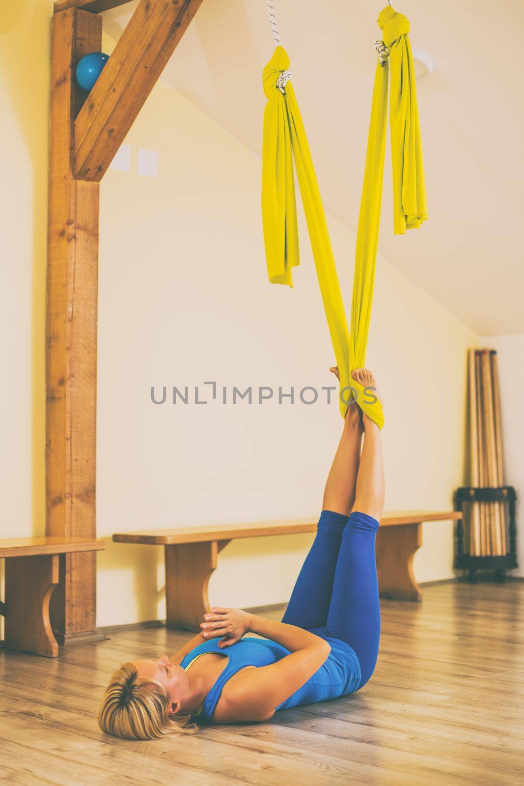 Woman doing aerial yoga in the fitness studio.Toned image.