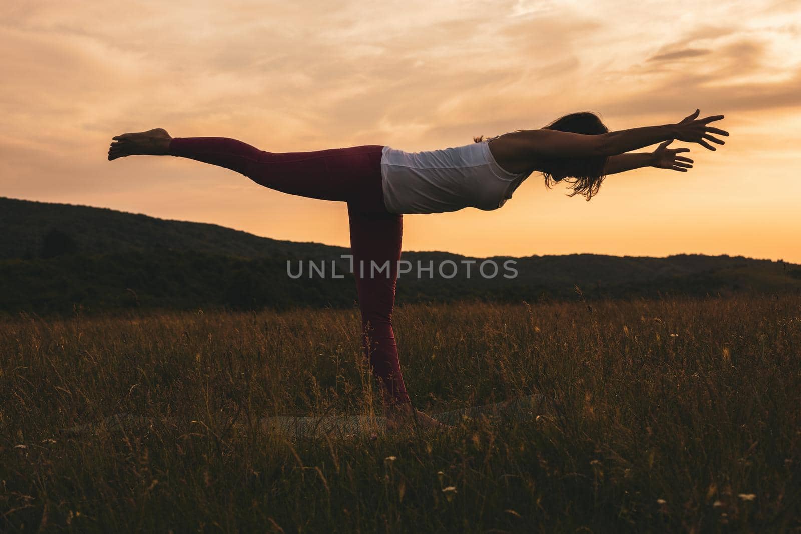 Silhouette of a woman practicing yoga/Virabhadrasana,Warrior Pose.