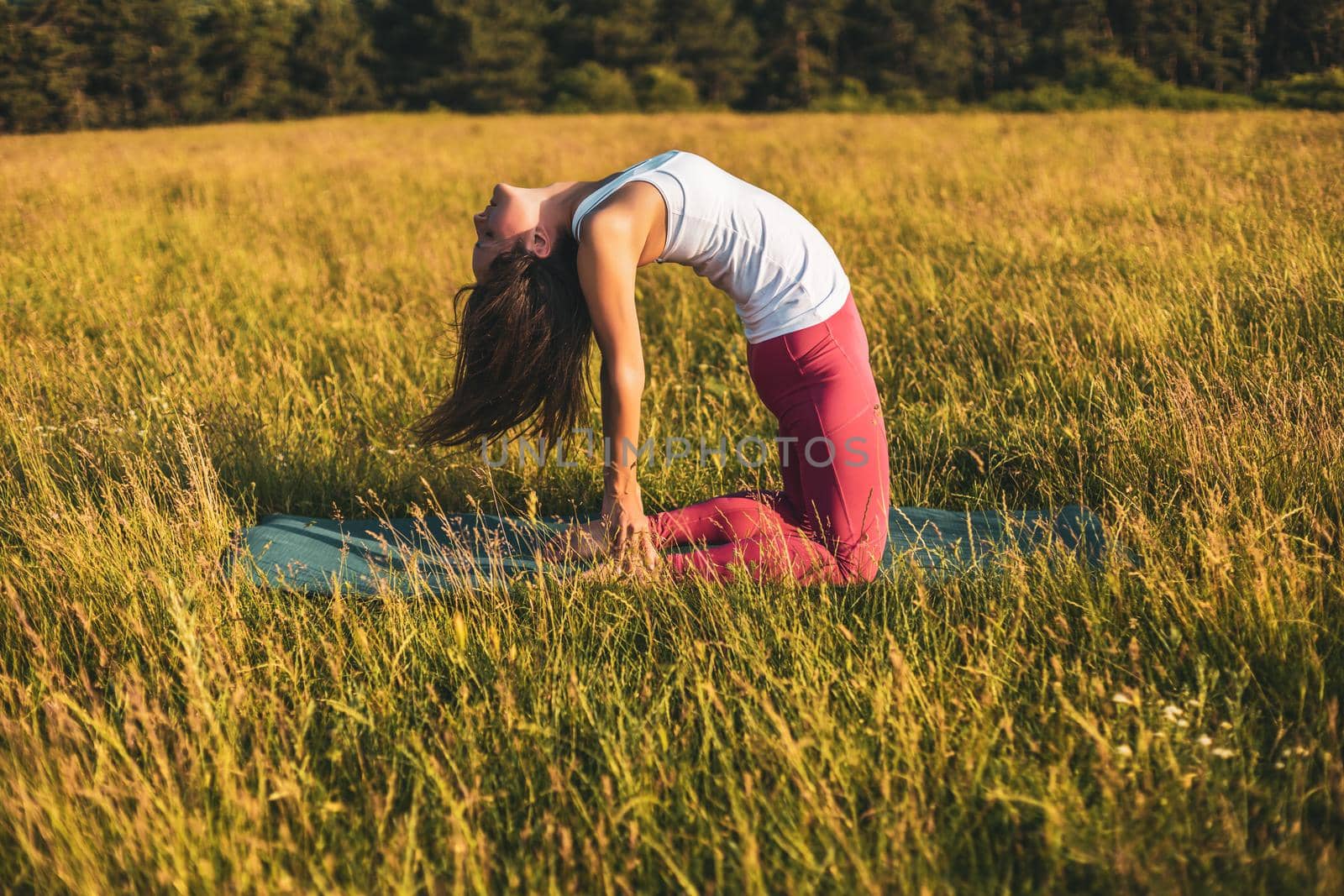 Beautiful woman doing yoga in the nature,Ustrasana/Camel pose