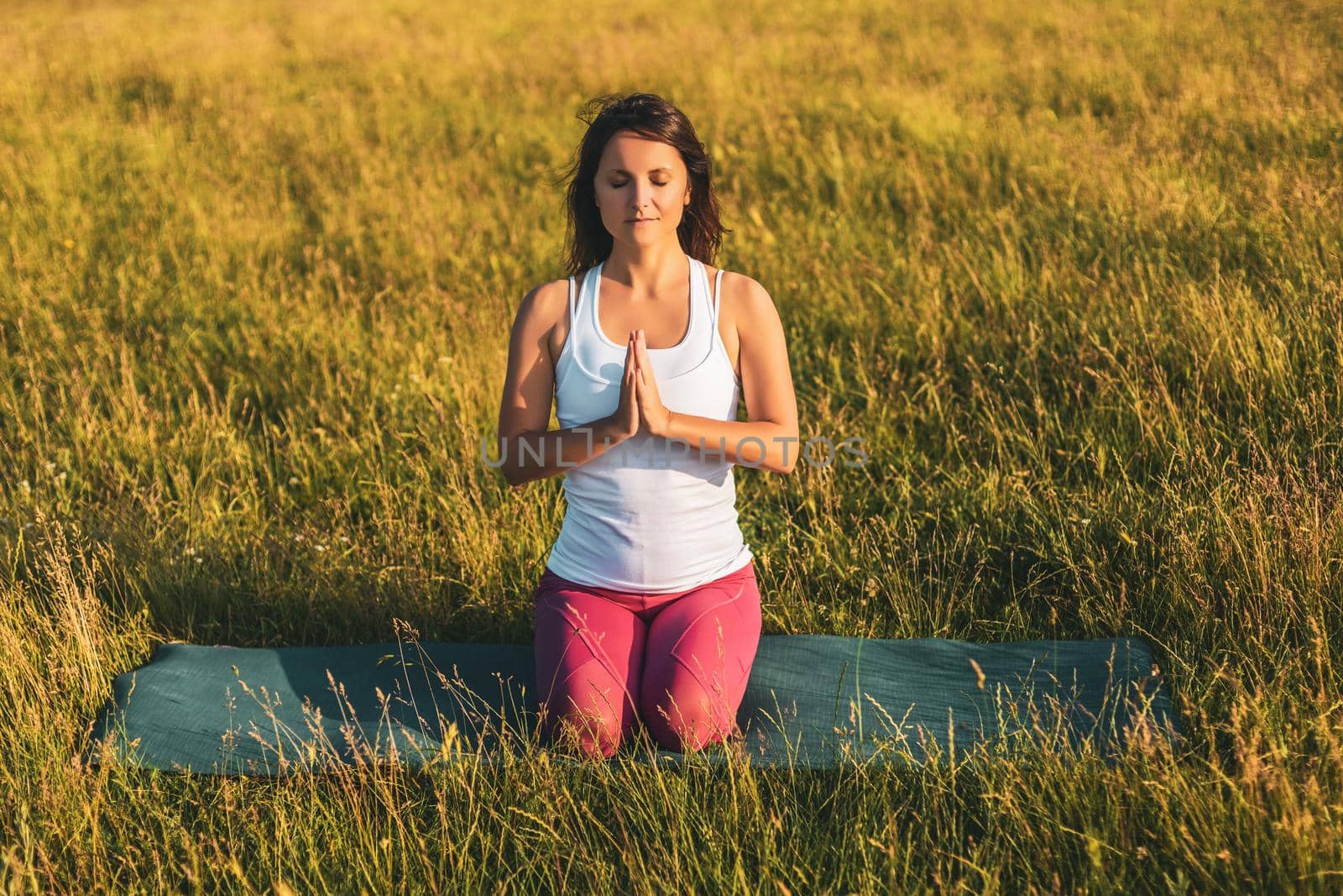 Beautiful woman is meditating in the nature.