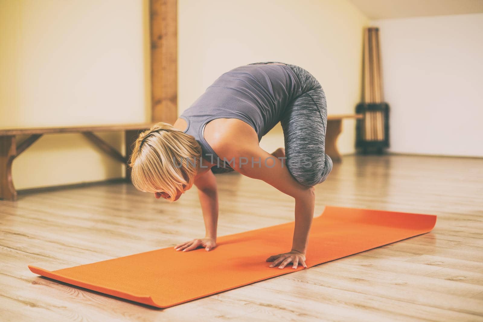 Woman doing yoga Bakasana/Crane Pose.Toned image.
