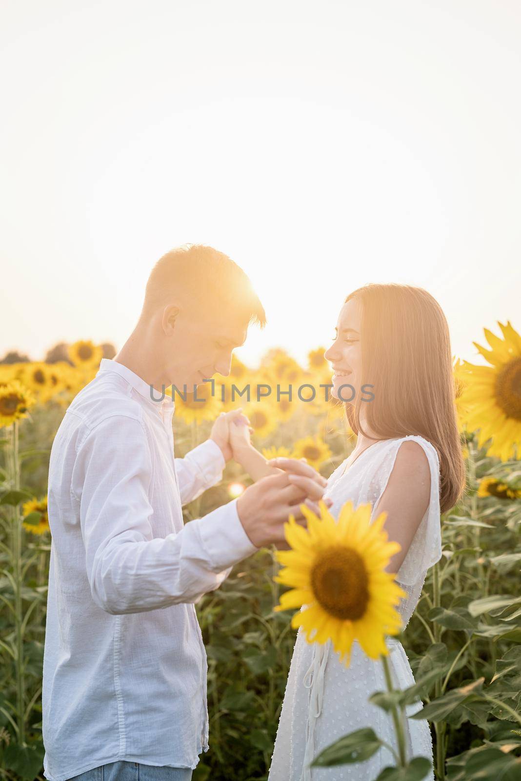 Beautiful couple having fun and dancing in sunflowers fields by Desperada