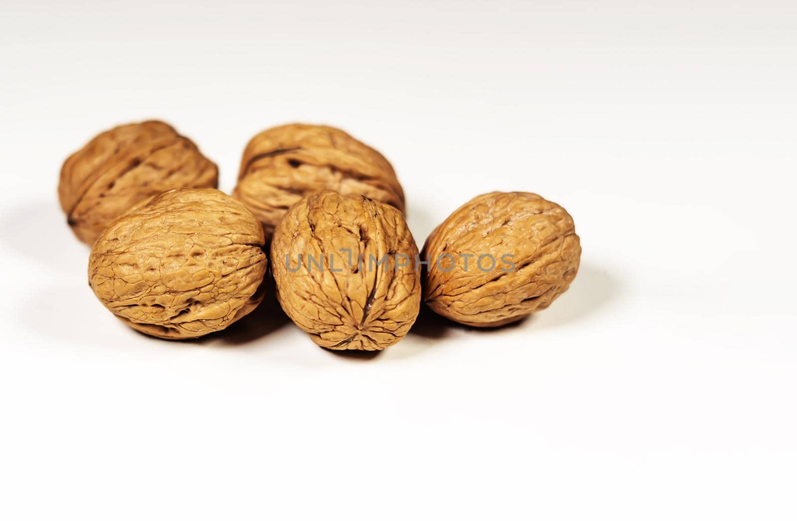A group of five walnuts isolated on a white background. Healthy lifestyle and food by rarrarorro