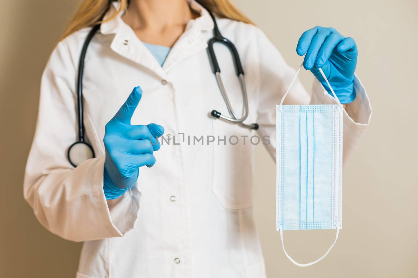 Image of female doctor holding protective face mask and scolding.