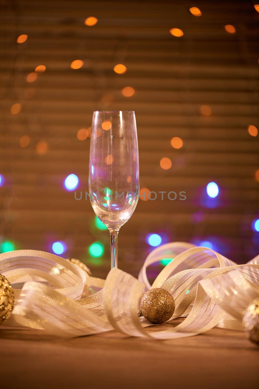 A glass with champagne and golden Christmas balls