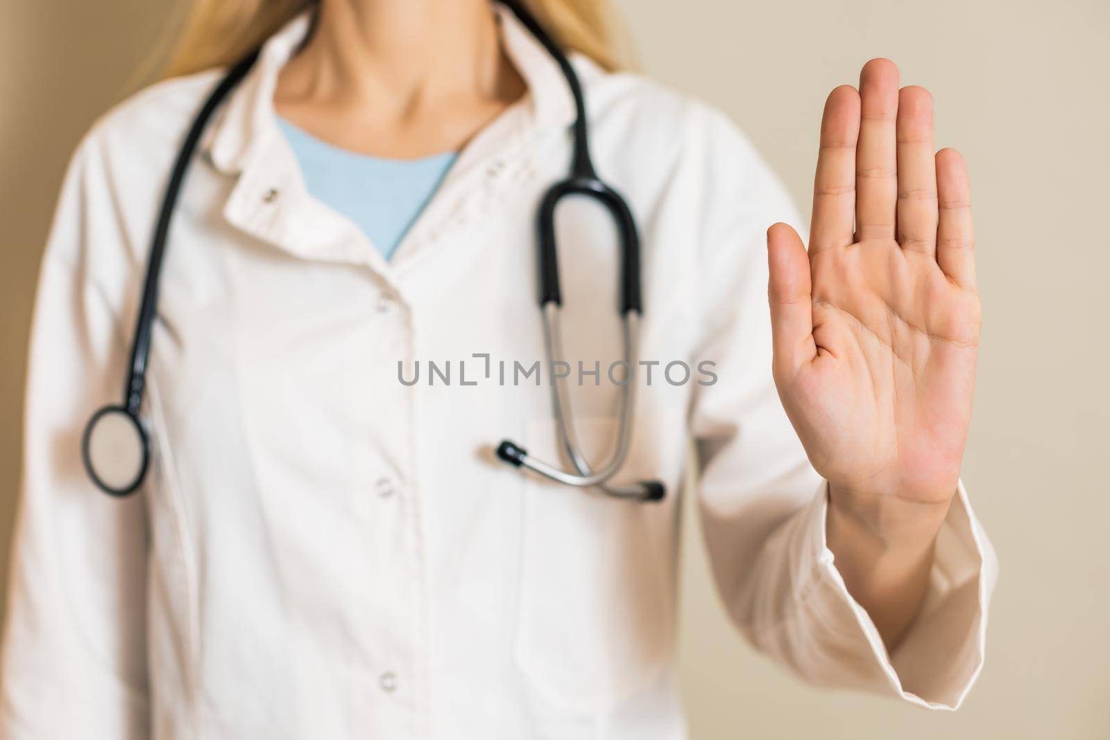 Image of female doctor showing stop sign.