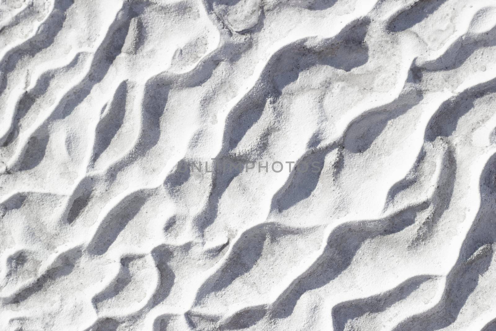 Gray texture background of Pamukkale calcium travertine in Turkey, pattern of diagonal waves, close-up.