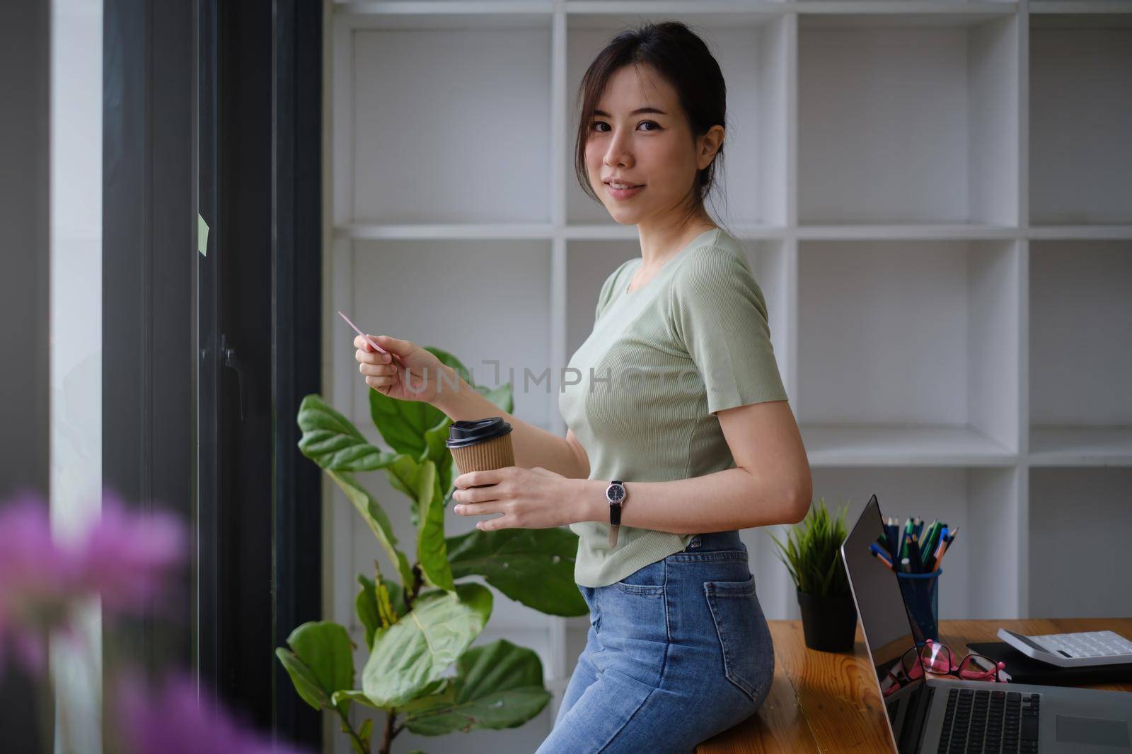 Asian Business woman taking note on sticky note. casual life and work from home concept