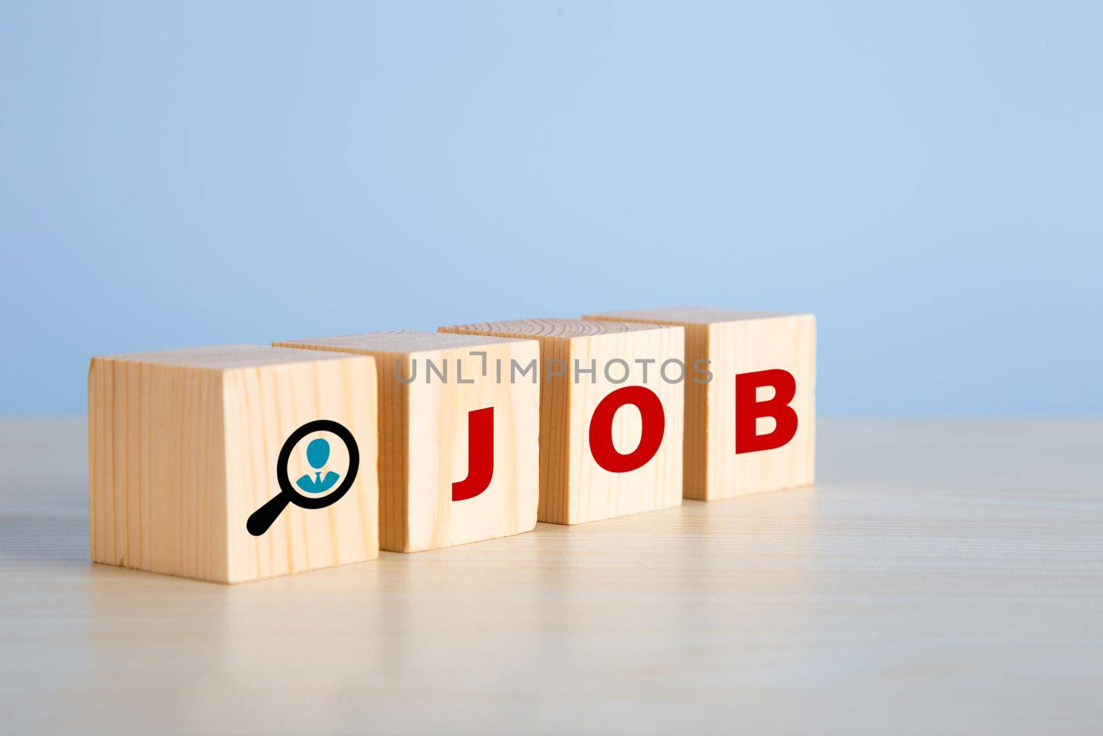 The word job on wooden cubes with on blue background. Searching for a job, employment, recruitment or career in business concept.