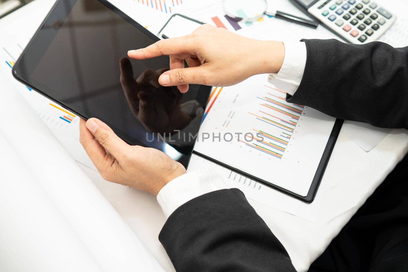 Asian accountant working and analyzing financial reports project accounting with chart graph and calculator in modern office, finance and business concept. by pamai