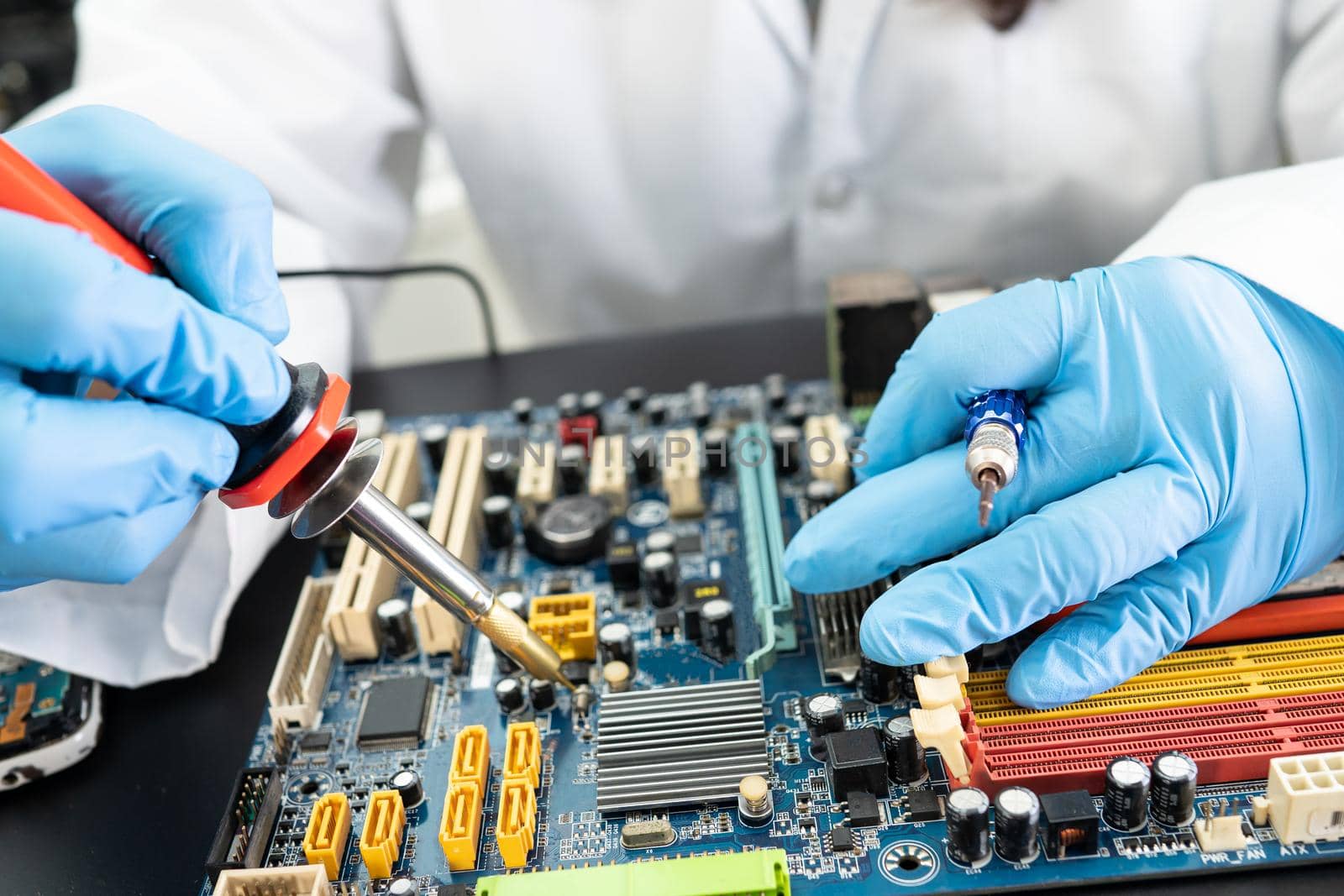 E-waste, technician repairing inside of hard disk by soldering iron. Integrated Circuit. the concept of data, hardware, technician and technology.