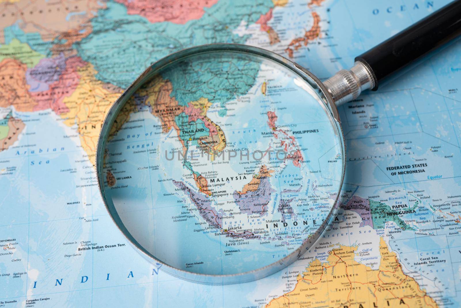 Bangkok, Thailand - August 01, 2020 Asia, Magnifying glass close up with colorful world map