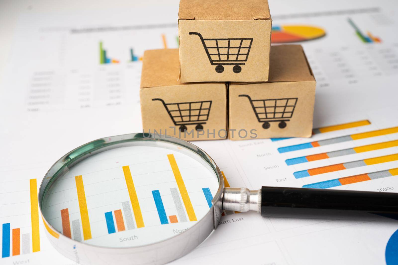 Shopping cart logo on box with magnifying glass on graph background. Banking Account, Investment Analytic research data economy, trading, Business import export transportation online company concept. by pamai